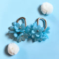 Blue polymer clay blossom cluster earrings with silver-tone hoops and metallic flower centers